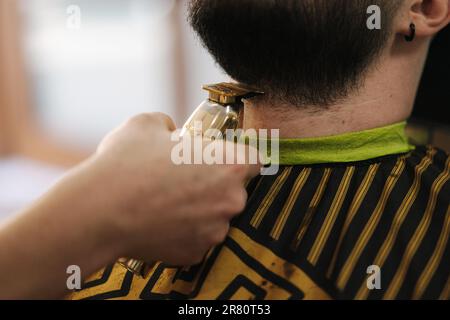 Primo piano dei rivestimenti professionali del barbiere per la barba del cliente. Bell'uomo barbuto in barbiere Foto Stock