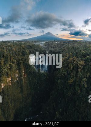 Vista dall'alto, splendida vista aerea delle cascate di Tumpak Sewu, note anche come Coban Sewu, con il vulcano Semeru in lontananza, la reggenza di Malang Foto Stock