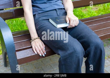 donna che chiede a dio tenendo la bibbia in grembo. La donna chiama Dio per aiuto. donna che recita una preghiera. Foto Stock