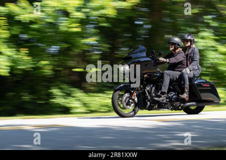 panoramica della foto di una motocicletta nera con due piloti che mostrano il movimento Foto Stock