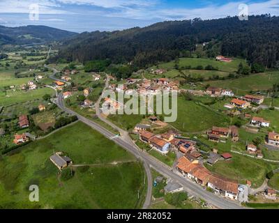 Viaggiare in auto nelle Asturie, nel nord della Spagna. Vista sul villaggio, case, giardini vicino a Villaviciosa. Foto Stock