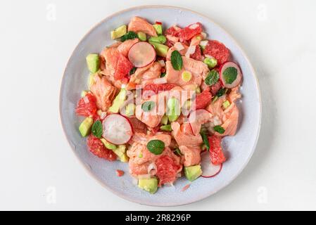 Ceviche fresche di salmone cileno fatte in casa con pompelmo, avocado, ravanello, cipolla e menta. Alimentazione sana Foto Stock