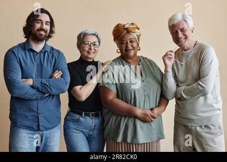 Gruppo di persone adulte diverse che si posano insieme e sorridono alla macchina fotografica Foto Stock