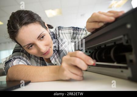 Donna che fissa una stampante Foto Stock