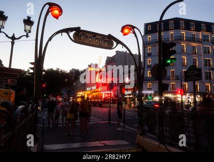 Parigi, Francia - Luglio, 15: Vista notturna della stazione metropolitana Metropolitan con decorazioni art nouveau con il Moulin Rouge sullo sfondo a Parigi su J Foto Stock