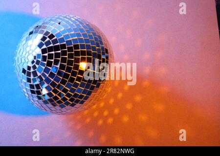 Brillante palla da discoteca su sfondo colorato. Spazio per il testo Foto Stock