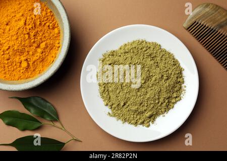 Composizione piatta con henné e polvere di curcuma su fondo corallo. Colorazione naturale dei capelli Foto Stock