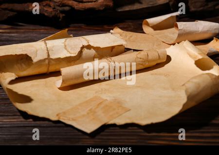 Fogli di vecchia carta pergamena su tavola di legno Foto Stock