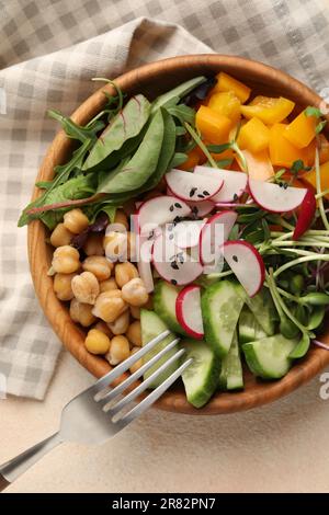 Delizioso recipiente vegano con cetrioli, ceci e ravanello su tavolo beige, vista dall'alto Foto Stock