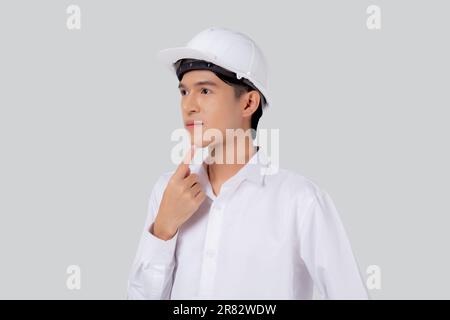 Ritratto giovane ingegnere asiatico uomo indossare casco pensando idea isolato sfondo bianco, architetto o appaltatore con la pianificazione e premuroso, contra Foto Stock