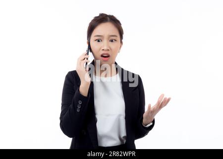 Ritratto giovane donna d'affari asiatica che parla e grida con fastidioso chiamata sullo smartphone isolato su sfondo bianco, donna d'affari grida e stress Foto Stock