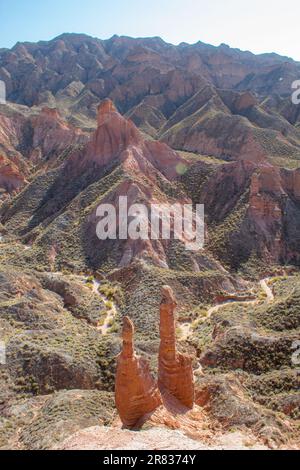 Paio di natura sculture in Danxia Binggou Canyon rilievi in Zhangye, Sunan Regione, Provincia di Gansu, Cina. Pietra arenaria rossa rocce del Geoparco. Rosso Foto Stock