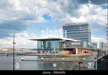 Amsterdam, Paesi Bassi - Muziekgebouw aan ‘t IJ sala da concerto e caffè entro il 3XN con Movenpick Hotel di Claus en Kaan Architecten attraverso il canale Foto Stock