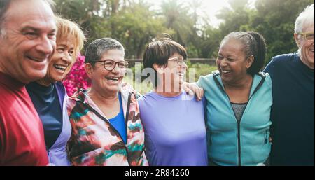 Persone anziane multirazziali che si divertono a vicenda dopo l'allenamento sportivo al parco cittadino - stile di vita sano e concetto di stile di vita gioioso degli anziani Foto Stock