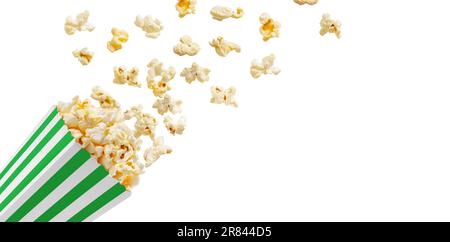 Popcorn che vola fuori dalla scatola di carta verde a strisce bianche isolato su sfondo bianco con spazio di copia. Spruzzi, levitazione di grani di popcorn. Foto Stock