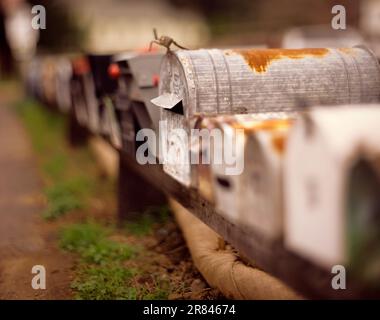 Una lunga fila di caselle postali è una strada rurale in California. Foto Stock