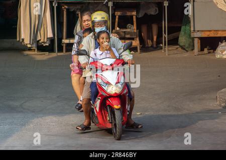 SAMUT PRAKAN, THAILANDIA, MAR 03 2023, una coppia anziana sta guidando una moto con bambini piccoli Foto Stock