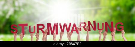 People Hands Building Word Sturmwarnung significa Storm Warning, Grass Meadow Foto Stock