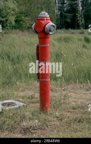 Idrante di fuoco nel campo - tubo rosso con acqua nel polacco Foto Stock