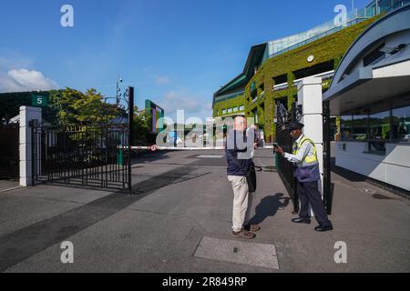 Londra Regno Unito. 19 giugno 2023 . Una guardia di sicurezza che controlla un visitatore alle porte principali dell'All England Lawn Tennis Club. È stato riferito che gli attivisti del clima di Stop Oil stanno tracciando per distruggere i campionati di Wimbledon come parte di una campagna in corso per costringere il governo a smettere di rilasciare nuove licenze di esplorazione petrolifera incollandosi a Centre Court quando il torneo di Grand Slam inizia in scadenza tra due settimane Il 3 luglio. Credit: amer Ghazzal/Alamy Live News Foto Stock