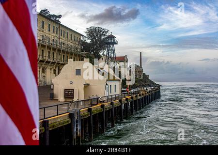 Molo e porto della prigione federale di massima sicurezza di Alcatraz nella Baia di San Francisco, nello stato della California, con la bandiera degli Stati Uniti. Foto Stock