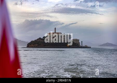 Isola nella Baia di San Francisco, dove si trova la famosa prigione federale di massima sicurezza di Alcatraz, in California, con la bandiera degli Stati Uniti. Foto Stock
