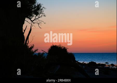 Ripida costa sull'isola di Poel al tramonto con vista del cielo pastello sulle rocce che si trovano nel Mar Baltico. Paesaggio girato dalla costa Foto Stock