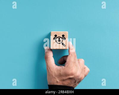 Assunzione e occupazione. Cercare e trovare il dipendente più adatto per un posto di lavoro vacante. La mano maschile posiziona un cubo di legno con la ricerca dei dipendenti symb Foto Stock