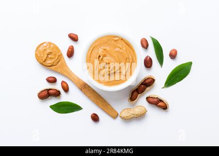 Ciotola di burro di arachidi e arachidi sullo sfondo del tavolo. vista dall'alto con spazio di copia. Pasta cremosa alle arachidi in un piccolo recipiente. Foto Stock