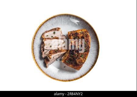 Pancia di maiale filippino marinata con crosta in un piatto. Isolato su sfondo bianco Foto Stock