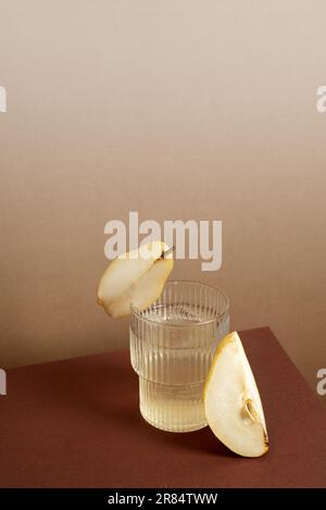 Immagine di un cocktail rinfrescante in un calice da highball con fette di pera Foto Stock