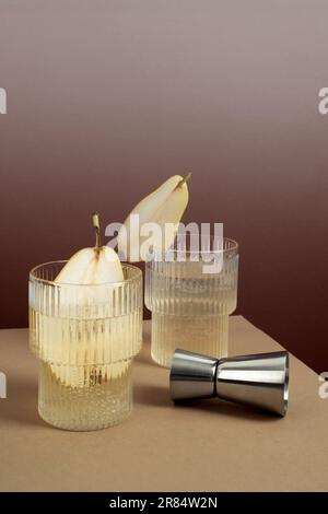 Immagine di un cocktail rinfrescante in un calice da highball con fette di pera Foto Stock