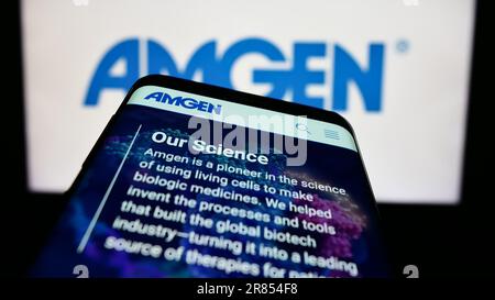 Telefono cellulare con pagina web della società biofarmaceutica statunitense Amgen Inc. Sullo schermo di fronte al logo aziendale. Messa a fuoco in alto a sinistra del display del telefono. Foto Stock