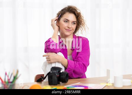 Ritratto di Pensive fotografo professionista Donna che lavora a casa interno ufficio Foto Stock