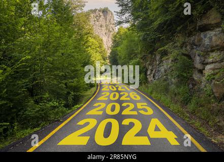 La parola 2024 scritta su strada nel mezzo di una strada asfaltata vuota all'alba. Idea di un piano d'azione aziendale di 2024 anni e obiettivi conseguiti Foto Stock