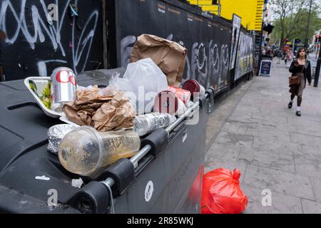 Il 25th maggio 2023 a Londra, Regno Unito, la lettiera si è accumulata in cima al bidone per la raccolta dei rifiuti e il riciclaggio lungo Whitechapel High Street. Foto Stock