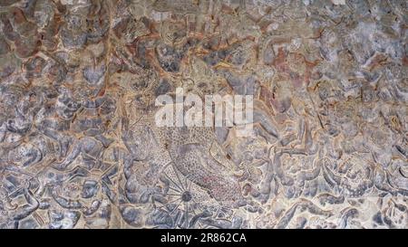 Muro di pietra con intricate sculture di scene di battaglia della mitologia indù, rinvenuto in un antico tempio Khmer, che mostra la profondità dell'arte antica Foto Stock