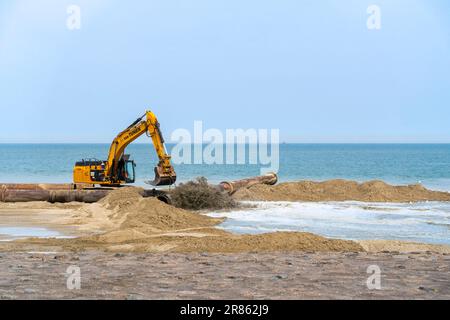 Escavatore idraulico cingolato utilizzato per il rifornimento di sabbia/nutrimento delle spiagge per ridurre i danni causati dalle tempeste lungo la costa olandese a Zeeland, Paesi Bassi Foto Stock