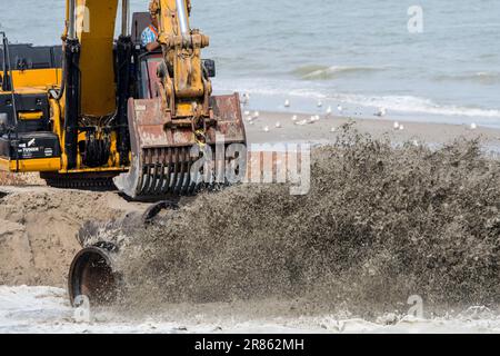 Escavatore idraulico cingolato utilizzato per il rifornimento di sabbia/nutrimento delle spiagge per ridurre i danni causati dalle tempeste lungo la costa olandese a Zeeland, Paesi Bassi Foto Stock