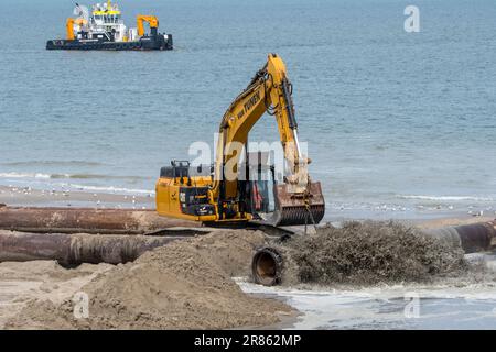 Escavatore idraulico cingolato utilizzato per il rifornimento di sabbia/nutrimento delle spiagge per ridurre i danni causati dalle tempeste lungo la costa olandese a Zeeland, Paesi Bassi Foto Stock