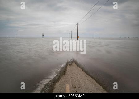 La strada è allagata. Il lago Tulare, situato nella Central Valley della California, è stato per decenni un lago asciutto, ma è tornato alla vita dopo le piogge maggiori d Foto Stock