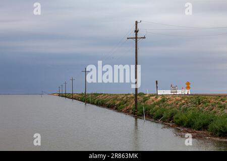 Strada chiusa. Il lago Tulare, situato nella Central Valley della California, è stato per decenni un lago asciutto, ma è tornato alla vita dopo le piogge più gravi durante Foto Stock