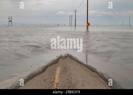 La strada è allagata. Il lago Tulare, situato nella Central Valley della California, è stato per decenni un lago asciutto, ma è tornato alla vita dopo le piogge maggiori d Foto Stock