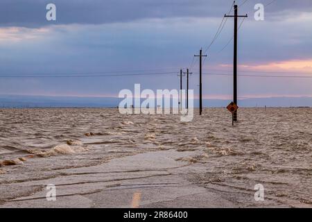 La strada è allagata. Il lago Tulare, situato nella Central Valley della California, è stato per decenni un lago asciutto, ma è tornato alla vita dopo le piogge maggiori d Foto Stock