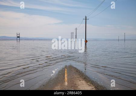 La strada è allagata. Il lago Tulare, situato nella Central Valley della California, è stato per decenni un lago asciutto, ma è tornato alla vita dopo le piogge maggiori d Foto Stock