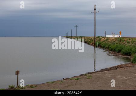 Strada chiusa. Il lago Tulare, situato nella Central Valley della California, è stato per decenni un lago asciutto, ma è tornato alla vita dopo le piogge più gravi durante Foto Stock