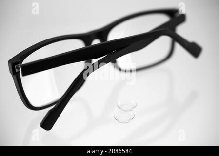 La scelta tra occhiali e lenti a contatto in bianco e nero Foto Stock