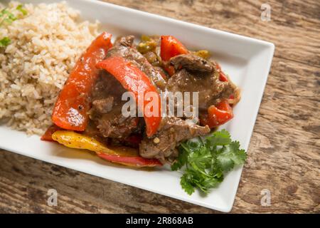 Fette di cervo di capriolo, Capreolus capreolus, cucinate con peperoni in salsa di fagioli neri. Inghilterra Regno Unito GB Foto Stock