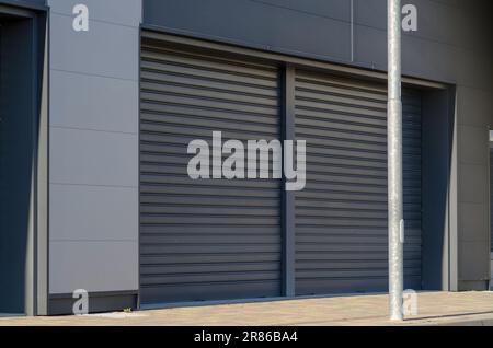 negozio chiuso, con persiane giù, sintomatico di scioperi, momento di crisi economica. facciata anonima. Foto Stock