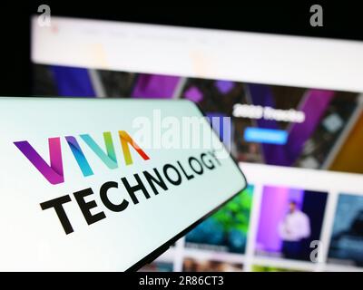 Smartphone con logo della conferenza francese Viva Technology (VivaTech) sullo schermo di fronte al sito Web aziendale. Messa a fuoco a sinistra del display del telefono. Foto Stock